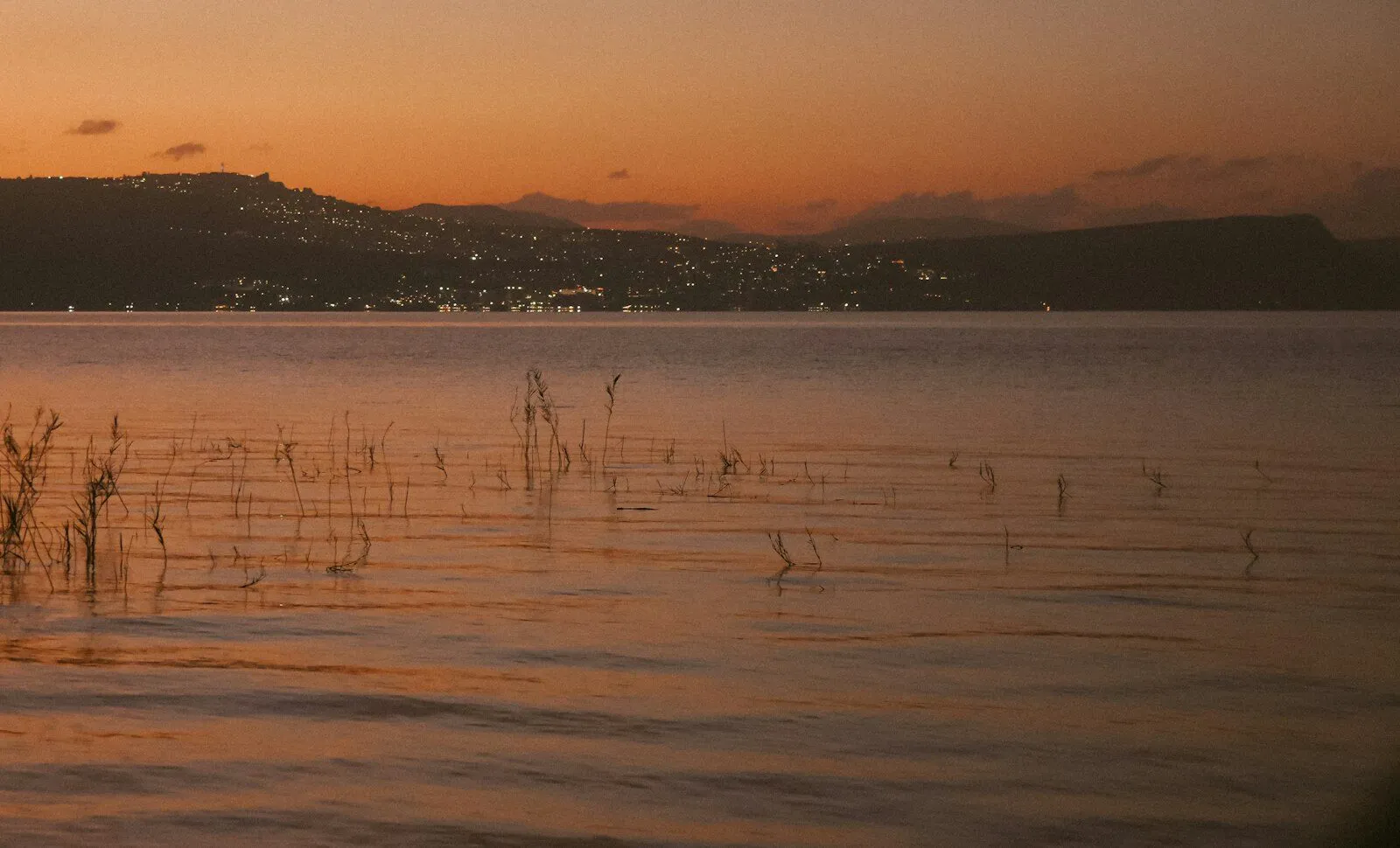 Sunset over the Sea of Galilee with the lights of Tiberias on the far shore